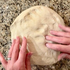 hands patting some sourdough dough