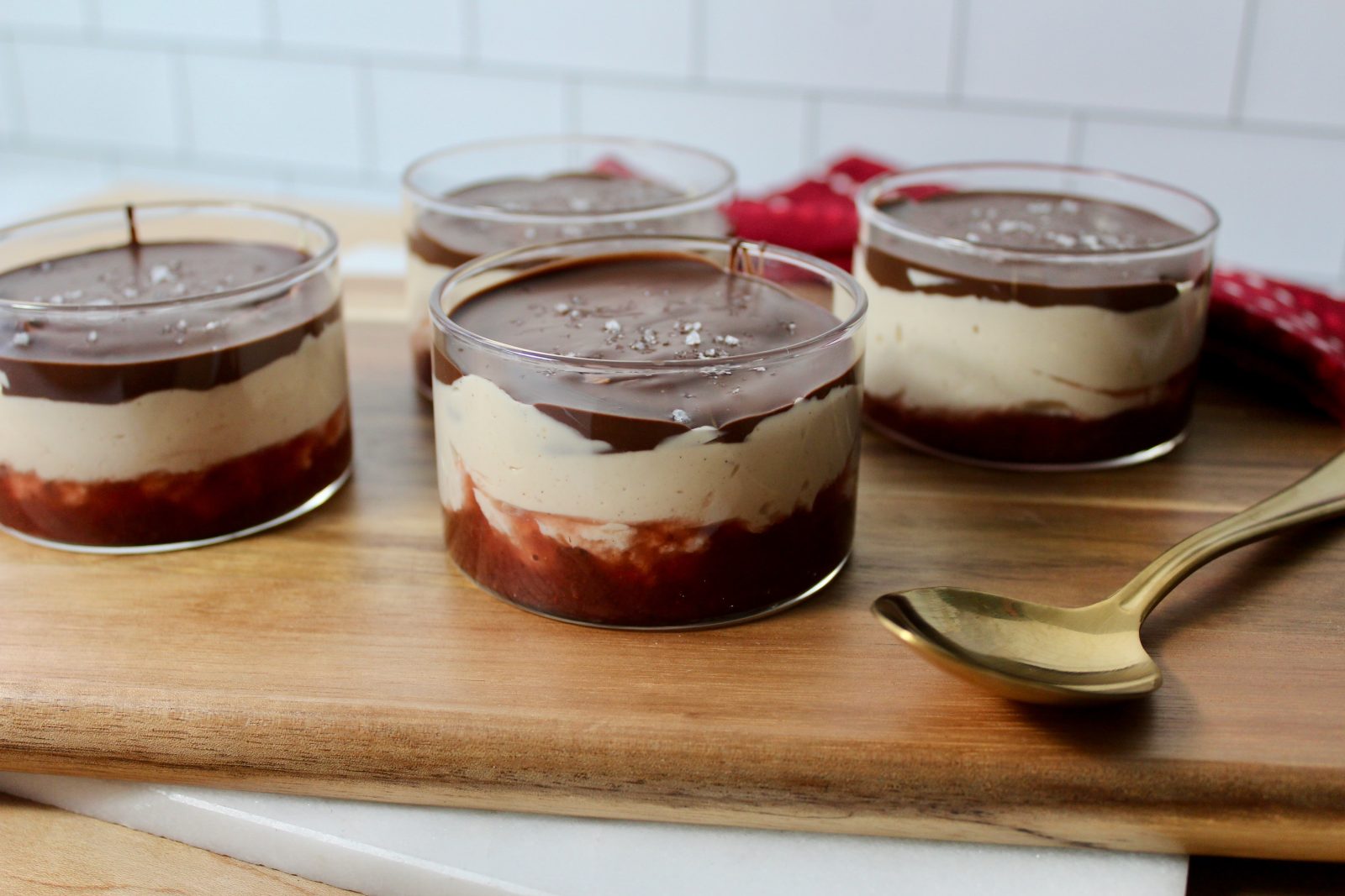 Greek Yogurt Cups - Recipe Photo showing 4 glass cups with layered jam, peanut butter fluffy yogurt mixture and a chocolate shell topping and a sprinkling of sea salt.